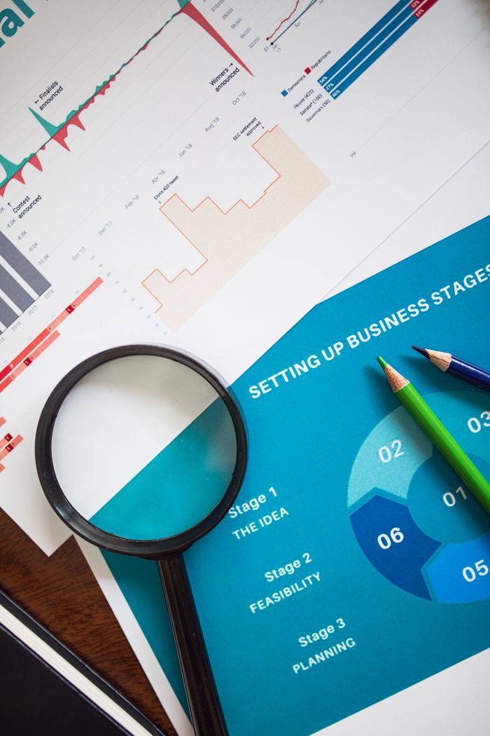 gallery-2 Magnifying glass and charts illustrate business analysis and planning concepts.